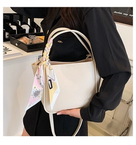 Detail of beige lychee leather tote with a decorative patterned silk scarf handle