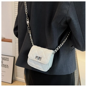 Close-up of white quilted leather crossbody bag with silver chain and metal clasp