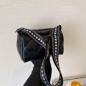 Chic black quilted cylinder crossbody bag with stylish wavy patterned wide fabric strap