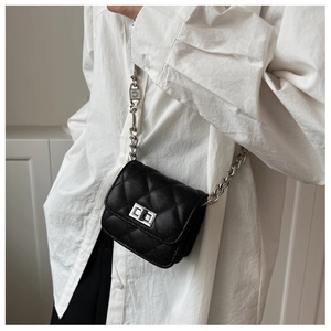 Detailed view of black quilted leather mini bag with silver chain and metal lock
