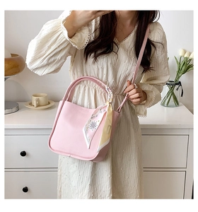 Pink lychee grain leather bucket bag with decorative printed silk scarf on the handle