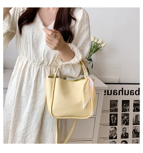 Detail of beige leather tote with floral silk scarf handle and adjustable strap