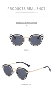 Detail view of matte black cat eye sunglasses with gold trim and grey lenses C1