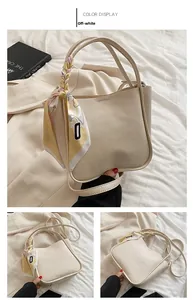 Detail of creamy white bucket bag featuring litchi texture and silk scarf handle