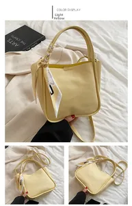 Detail of light yellow lychee pattern leather bucket bag with decorative silk scarf handle
