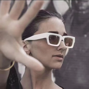 Close-up of Y2K steampunk white rectangular sunglasses with thick temples on a model