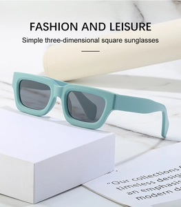 Detail of mint green steampunk square sunglasses featuring thick frames on a white marble base