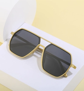 Detail van gepolariseerde aviator zonnebril met goud geometrisch montuur op voet