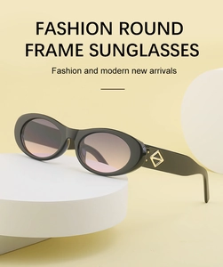 Détail de lunettes de soleil ovales noires avec décor doré et verres dégradés