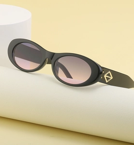 Détail de lunettes ovales avec verres dégradés roses et décorations dorées sur les branches