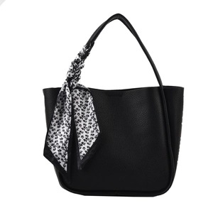 Minimalist black lychee leather tote bag with a decorative floral silk scarf handle