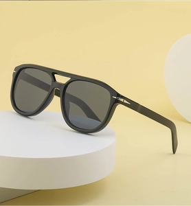 Detail of double-bridge aviator sunglasses featuring a silver arrow hinge on black frames