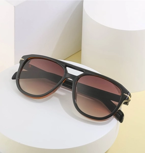 Close-up of vintage double-bridge sunglasses with brown gradient lenses and gold accents