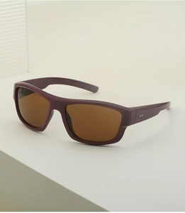 Détail de lunettes de soleil Y2K avec monture violette et verres ambrés polis