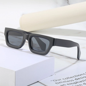 Steampunk Y2K rectangle sunglasses with thick black frame and grey lenses on white marble