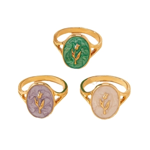 Three gold vintage tulip enamel rings in green, purple and cream on white background
