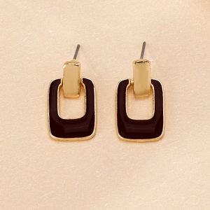 Detail of geometric rectangle drop earrings with gold metal and brown enamel finish