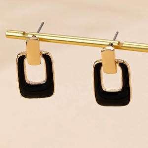 Detail of gold geometric hollow square earrings with elegant black enamel finish