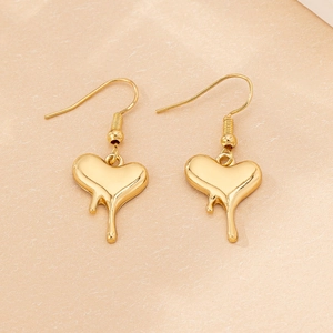 Macro shot of liquid metal heart earrings in gold finish with melting drip detail