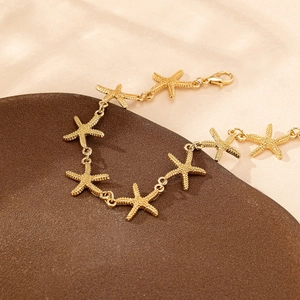 Gold starfish link bracelet with textured pendants and lobster clasp for beach wear
