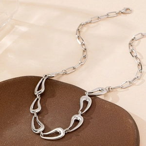 Collier asymétrique argenté élégant avec maillons gouttes évidés et chaîne trombone