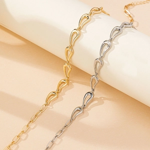 Colliers élégants avec pendentifs goutte en or et argent et chaîne trombone sur fond sable