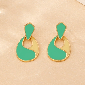 Detailed view of mint green and beige drop earrings with elegant golden metal framing
