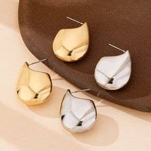 Elegant gold and silver water drop stud earrings set on a stylish display tray