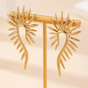 Golden sunburst stud earrings with textured radial lines on a minimalist T-bar jewelry stand