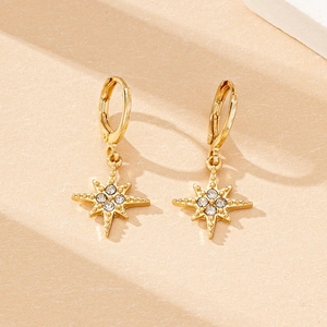 Macro shot of elegant gold starburst hoop earrings with sparkling rhinestones details