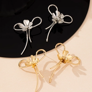 Minimalist flower-shaped stud earrings in polished gold and silver finishes
