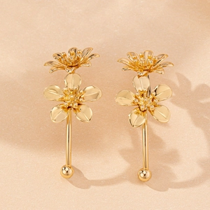 Detailed close-up of vintage golden double-layer flower earrings with textured petals