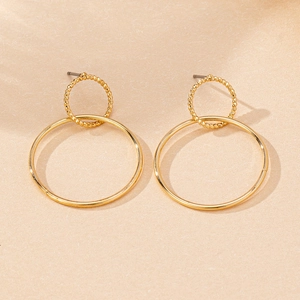 Close-up of geometric gold-tone hollow hoop earrings with textured and smooth finishes