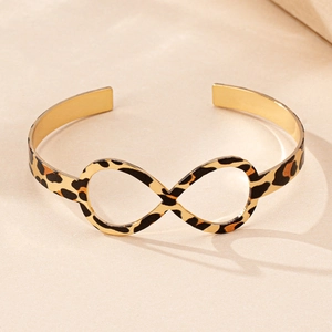 Detailed view of infinity symbol gold bangle featuring chic leopard print texture finish