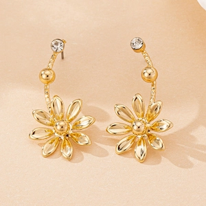 Macro shot of gold daisy flower earrings with sparkling rhinestones and textured petals