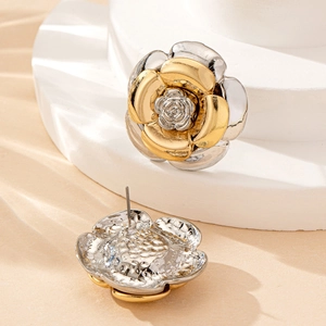 Élégantes boucles d'oreilles fleurs bicolores or et argent sur un socle en pierre blanche
