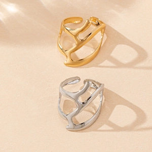 Minimalist gold and silver open rings with hollow organic branch design on beige background