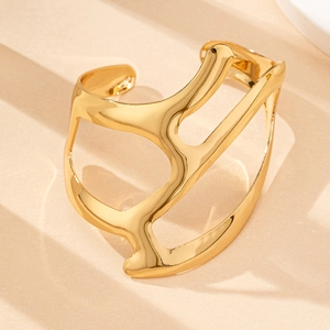 Gros plan d'un bracelet manchette doré irrégulier avec une texture miroir polie élégante