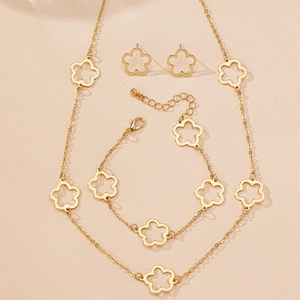 Detailed set of clover jewelry featuring a necklace, bracelet and earrings in gold