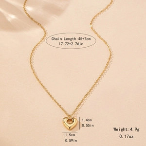Collier à pendentif cœur creux en or poli pour femme sur un fond minimaliste chaud