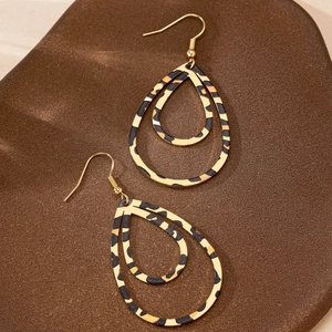 Retro hollow double-layered leopard print teardrop earrings on a textured brown surface