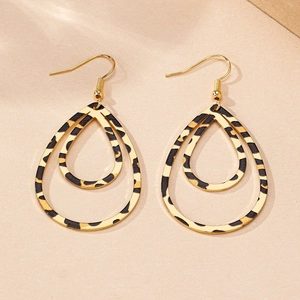 Detail of double teardrop earrings with leopard print patterns and golden hooks