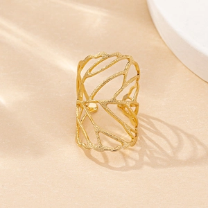 Close-up of golden hollow leaf texture ring with frosted finish on a stone surface