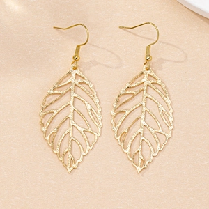 Detailed close-up of golden hollow leaf earrings with intricate bionic vein texture