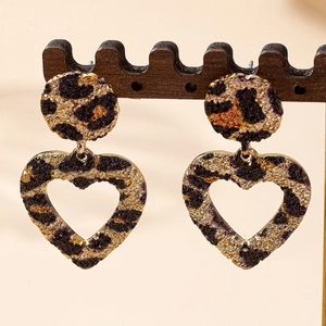 Elegant leopard print hollow heart drop earrings on a professional wooden jewelry stand