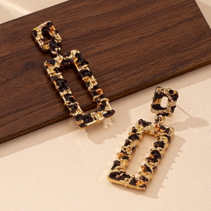 Elegant geometric square leopard print earrings with gold woven texture on dark wood background