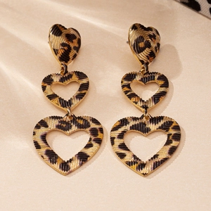 Detail of triple tiered leopard print heart earrings with a golden finish and textured surface