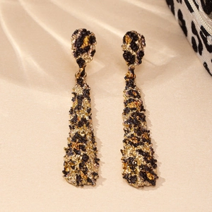 Detail of drop earrings featuring abstract black and gold leopard print texture