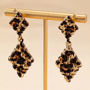 Elegant retro black and gold rhombus drop earrings with leopard texture on a display stand