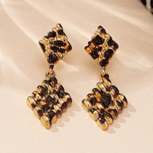 Close-up of geometric rhombus earrings with retro leopard pattern and gold plating